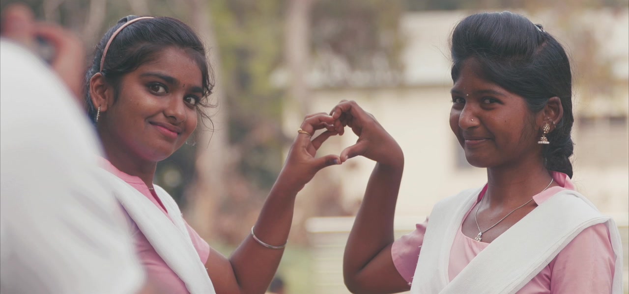 Two schoolgirls making a heart with their hands, Pune